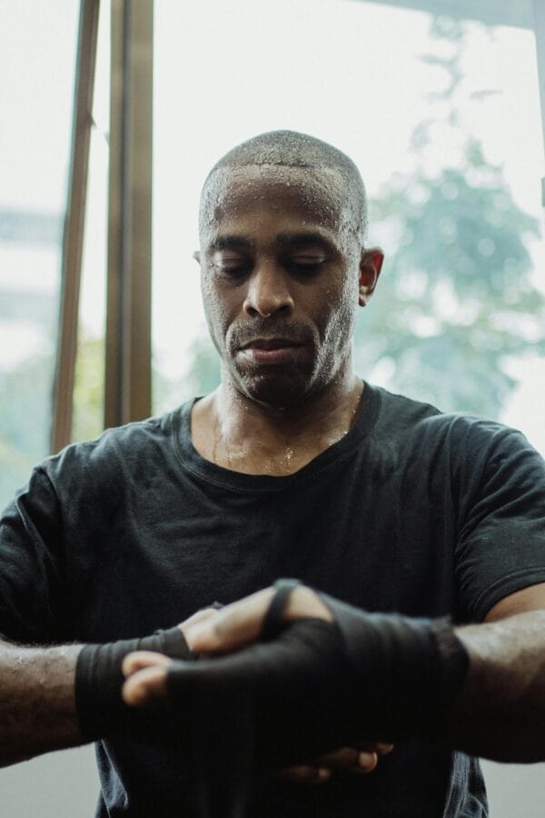 A Sportsman in Black Shirt Wrapping His Hand