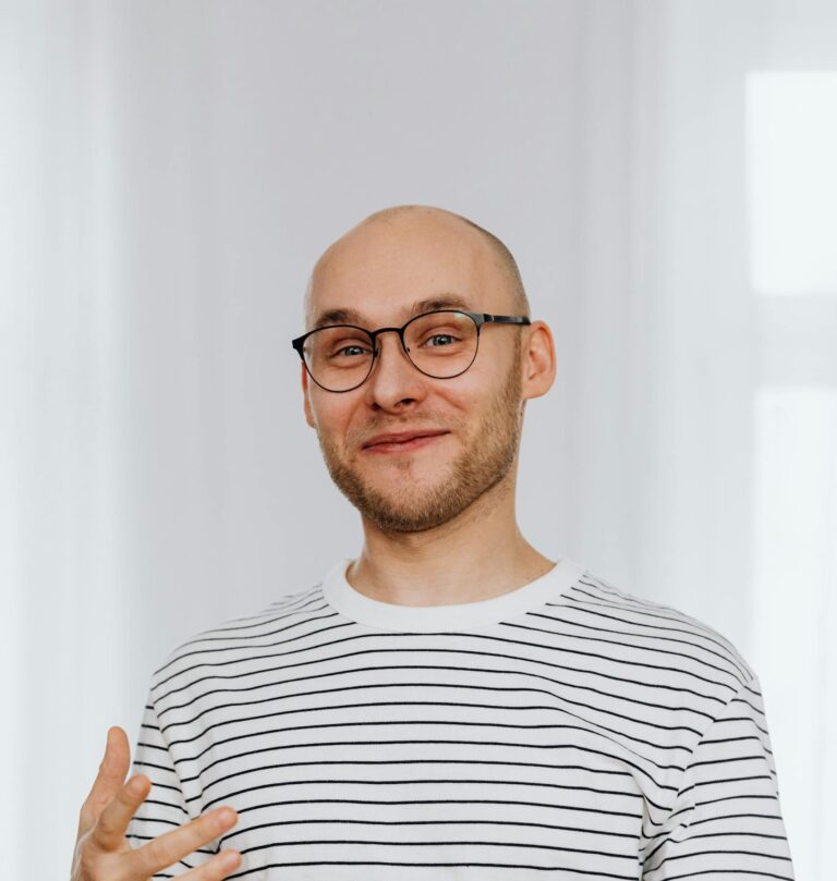 Man in White and Black Striped Shirt with Black Framed Eyeglasses